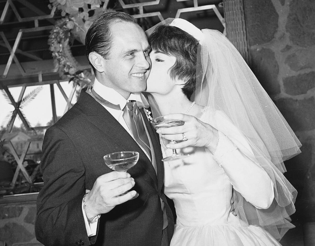 FILE - Comedian Bob Newhart, 33, and his bride Virginia Quinn, 22, kiss during toast at a recep ...