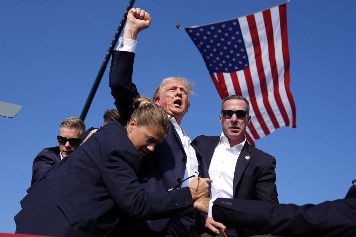 Republican presidential candidate former President Donald Trump raises his fist and calls out t ...