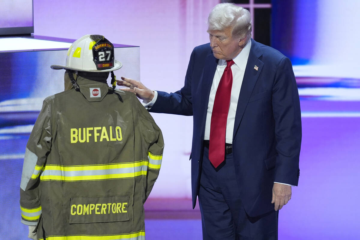 Republican presidential candidate former President Donald Trump standing next to the uniform of ...