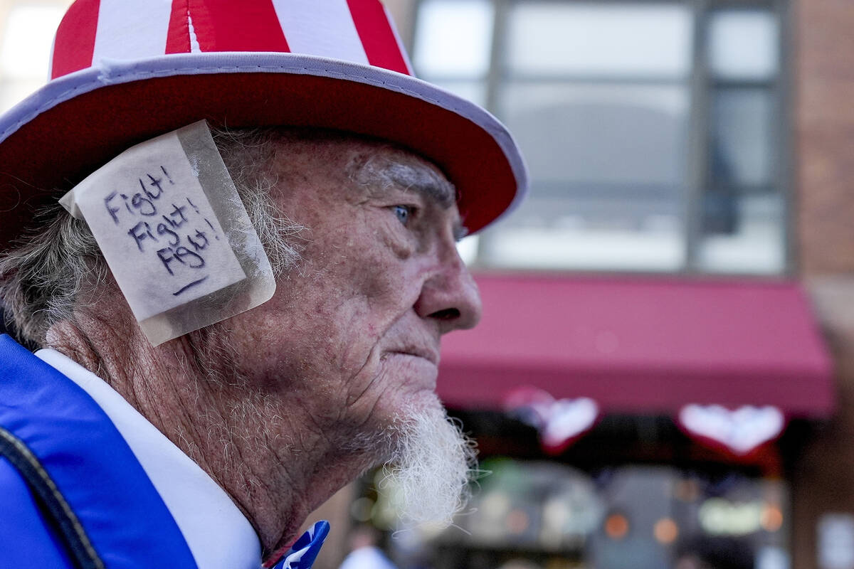 A supporter, donning an ear bandage in solidarity with former President Donald Trump after an a ...