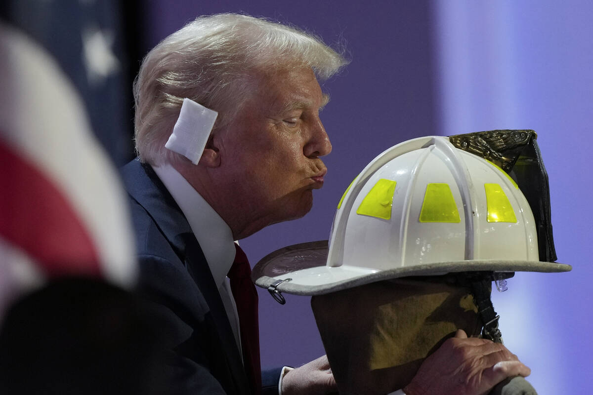 Republican presidential candidate former President Donald Trump kisses the helmet of Corey Comp ...