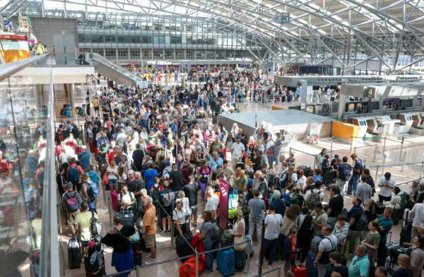 Travelers wait in Terminal 1 for check-in at Hamburg Airport, in Hamburg, Germany, Friday July ...