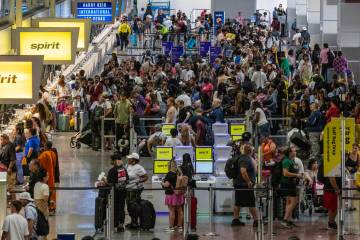 Passengers wait in line for the Spirit Airlines ticket desk at Harry Reid International Airport ...