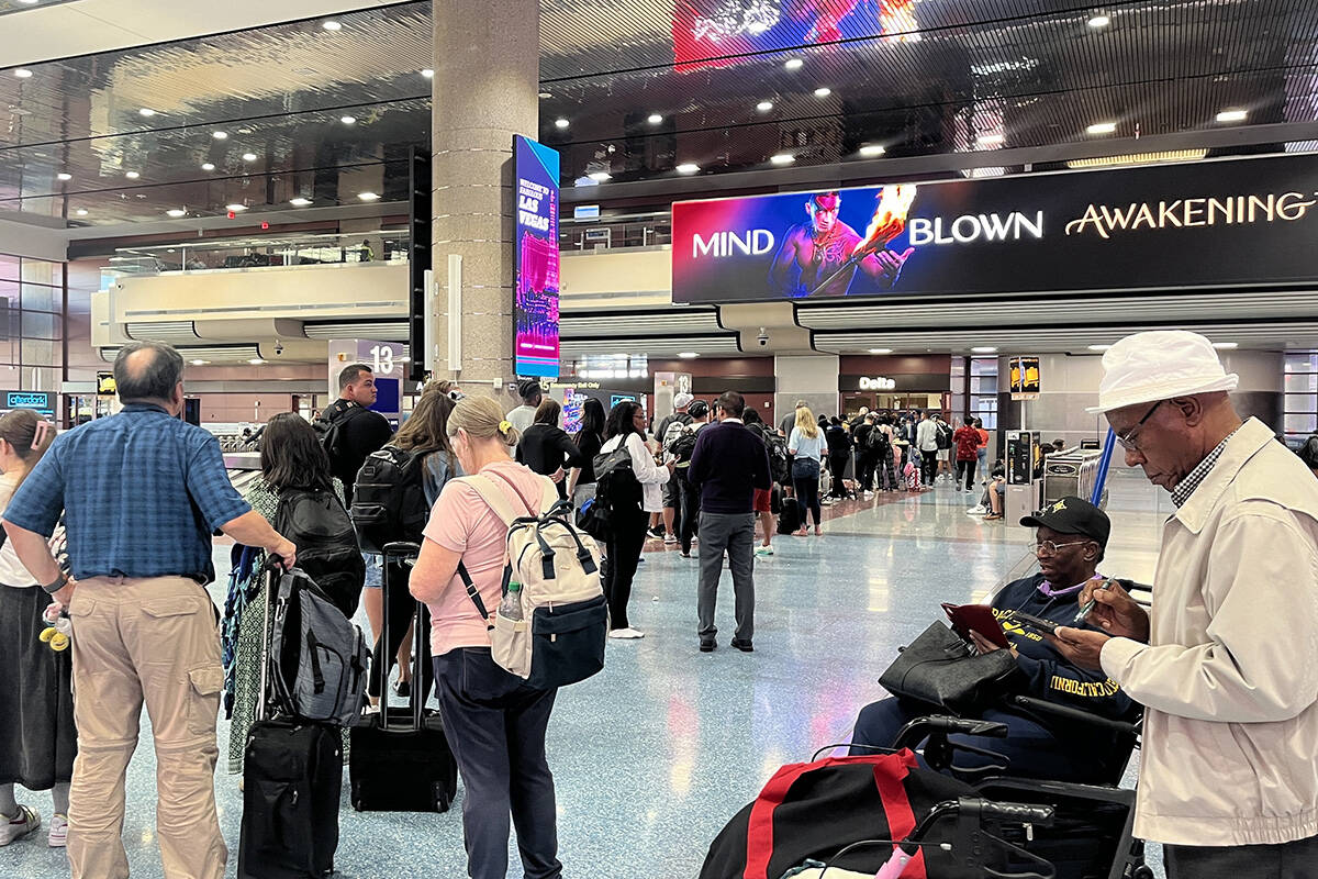 Travelers deal with a global technology outage Friday, July 19. 2024, at Harry Reid Internation ...