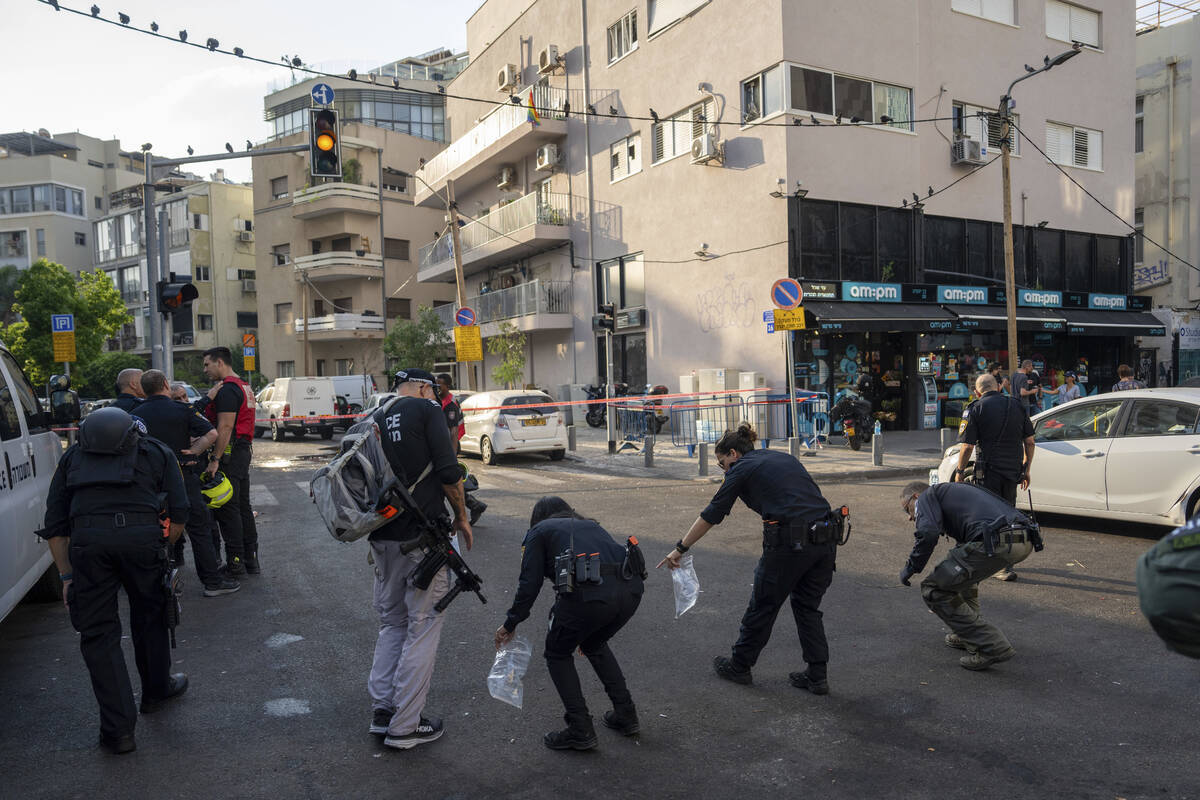 Israeli police investigate the scene of an explosive drone attack in Tel Aviv, Israel, Friday, ...