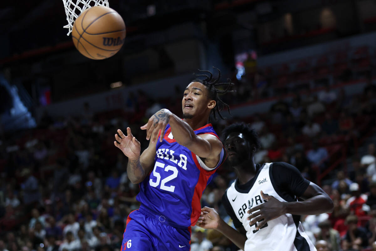 Philadelphia 76ers guard Judah Mintz (52) passes under the net while San Antonio Spurs forward ...