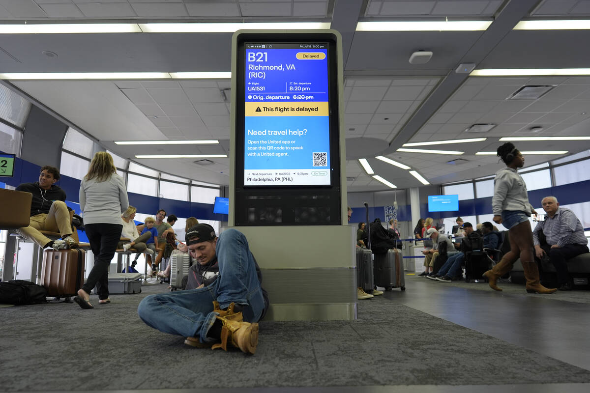 An information display near United gates shows a flight delay at Chicago O'Hare International A ...