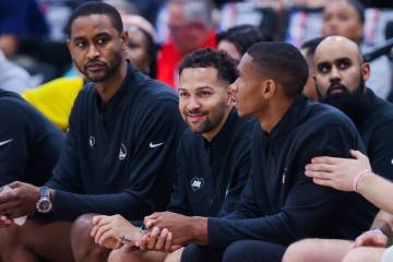 Golden State Warriors assistant coach Noah Robotham, middle, watches game action from the bench ...