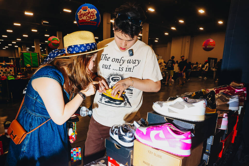 Attendees take a look at a pair of baby shoes during Sneaker Con at the Mandalay Bay Convention ...