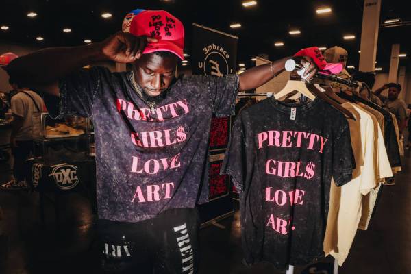 Remy Primas, who owns a clothing brand called Art By Hollywood, shows off clothing he is sellin ...