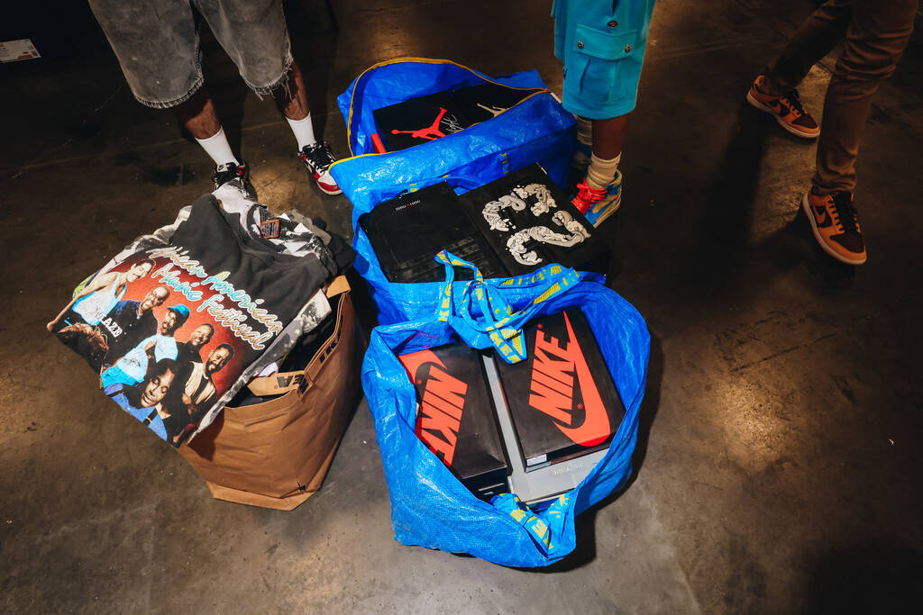 Shoes and shirts bought by an attendee during Sneaker Con lay on the floor during a trade at th ...