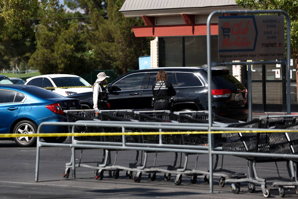 Metropolitan Police Department officers investigate a taped-off scene at a shopping center park ...