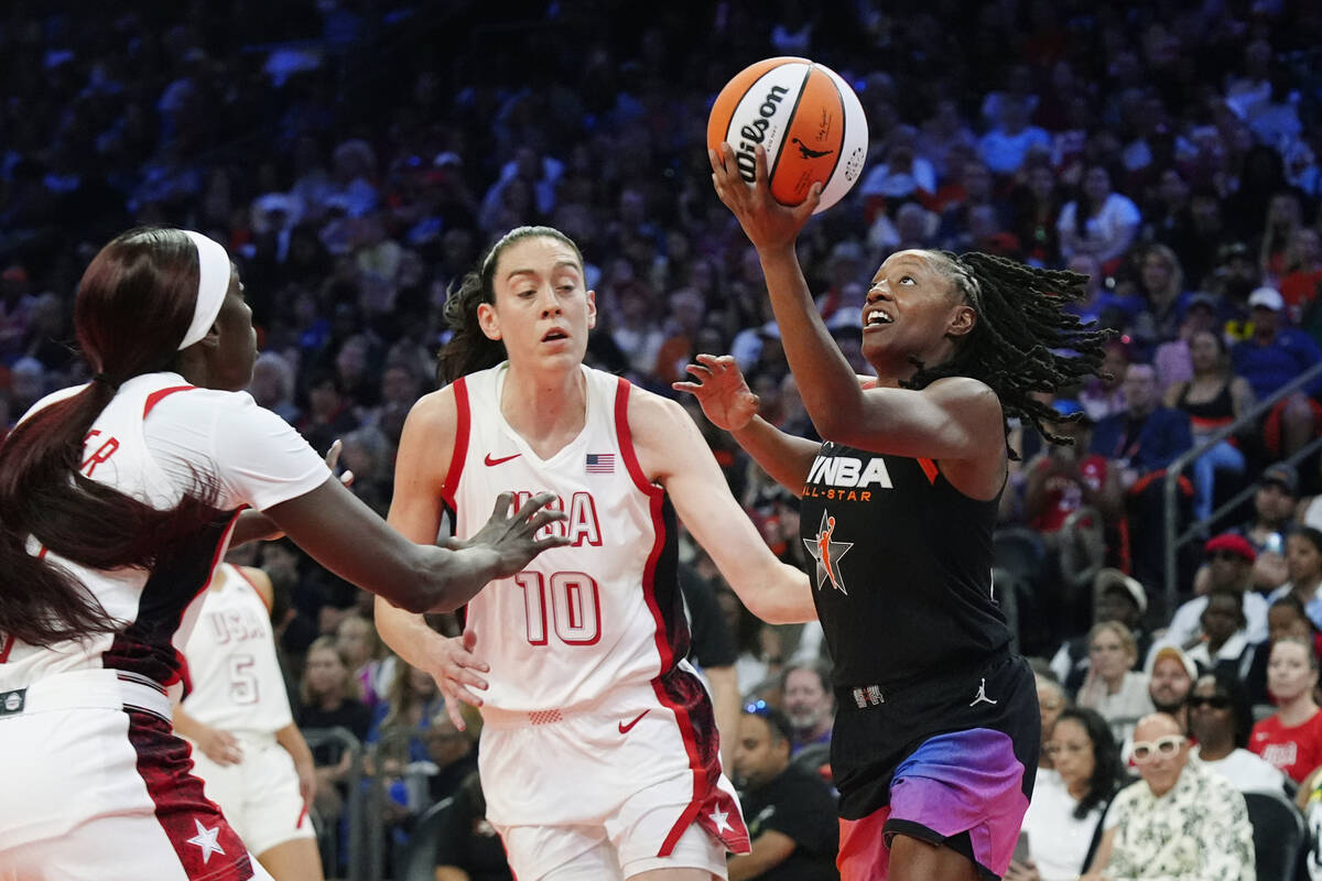 Kelsey Mitchell, right, of Team WNBA, drives past Breanna Stewart (10), of Team USA, and Kahlea ...
