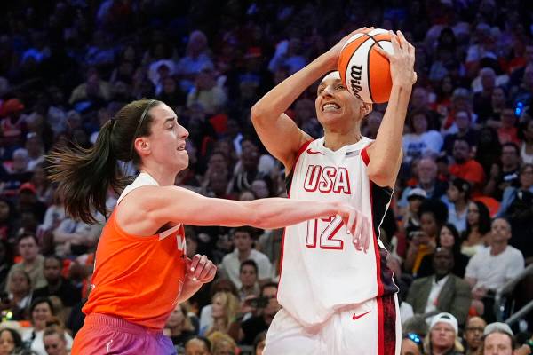 Diana Taurasi (12), of Team USA, is fouled by Caitlin Clark, left, of Team WNBA, during the fir ...