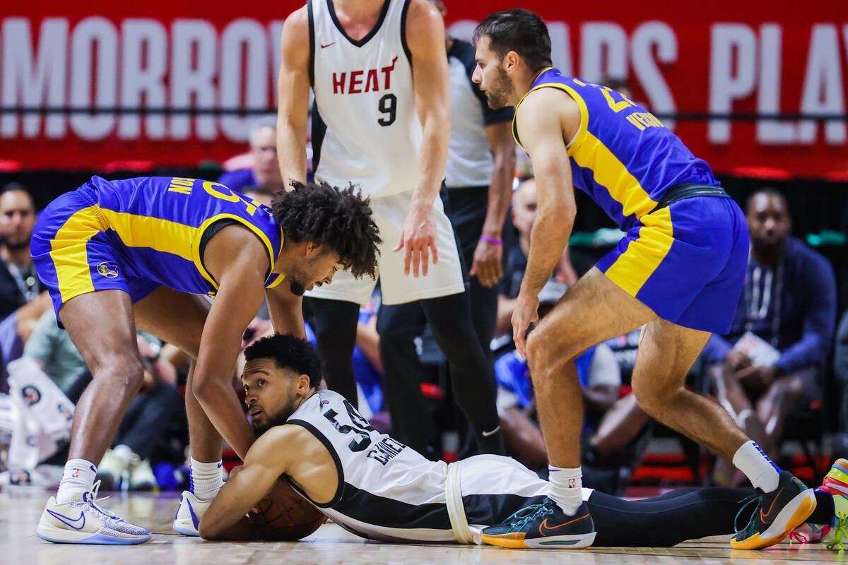 Miami Heat guard Caleb Daniels (54) hangs onto the ball as he looks to a referee to blow his wh ...