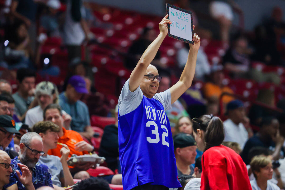 A basketball fan holds up a sign saying “Beware of Kelel” in reference to Miami H ...