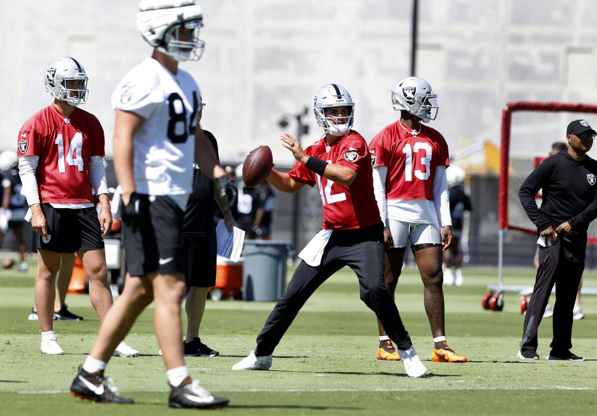 Raiders quarterback Aidan O'Connell (12) prepares to throw the ball as quarterbacks Carter Brad ...