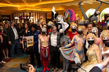 Cast members of "O," and Cirque du Soleil CEO Daniel Lamarre, center, pose for photos ...