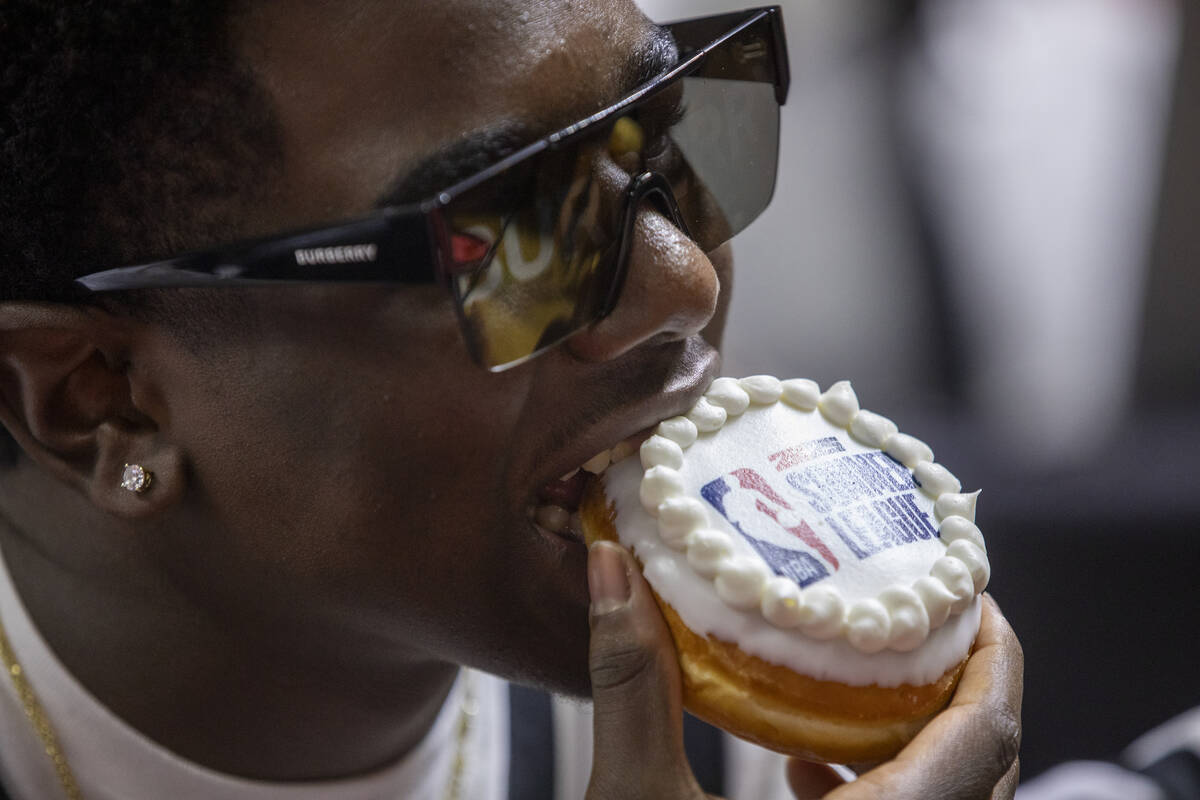 A fan eats a NBA Summer League doughnut during the Summer League Championship basketball game b ...