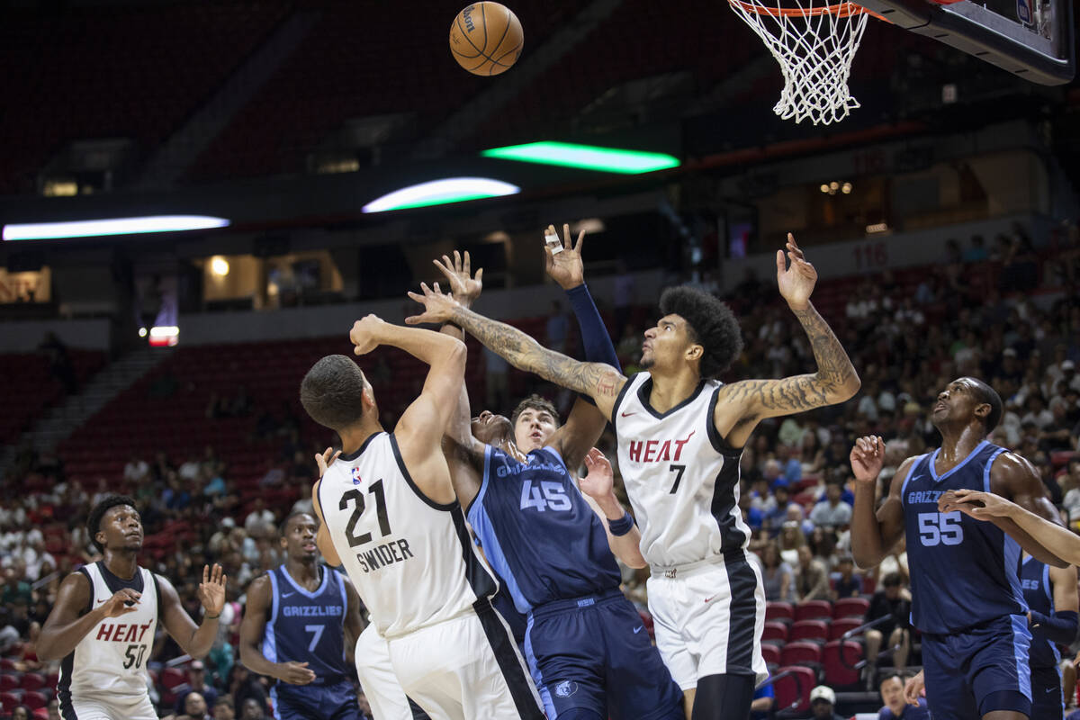 Miami Heat forward Cole Swider (21) and center Kel'el Ware (7) block Memphis Grizzlies forward ...