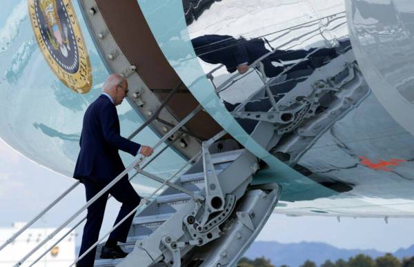 President Joe Biden walks up the steps of Air Force One at Harry Reid International Airport in ...
