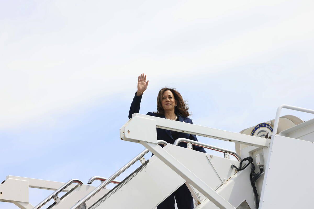 Vice President Kamala Harris waves while boarding Air Force Two as she departs on campaign trav ...