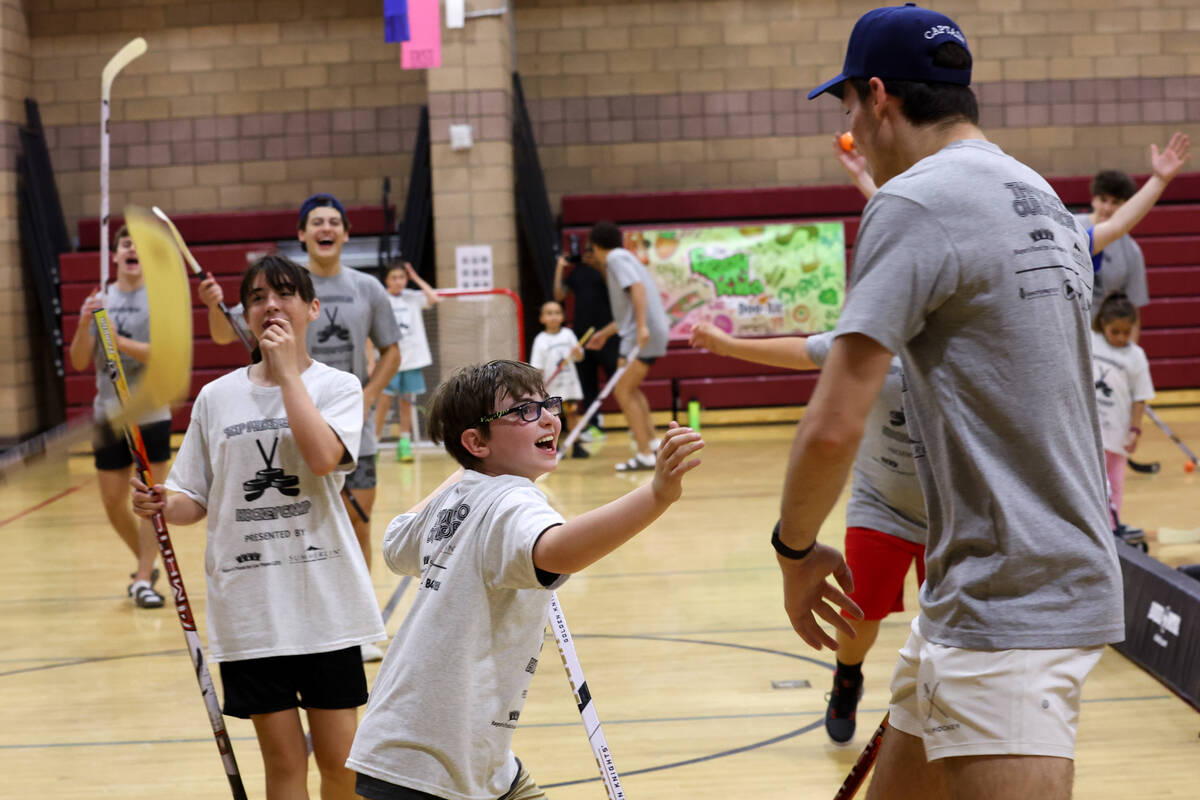 Local kids celebrate a goal during a street hockey camp at the Veterans Memorial Community Cent ...