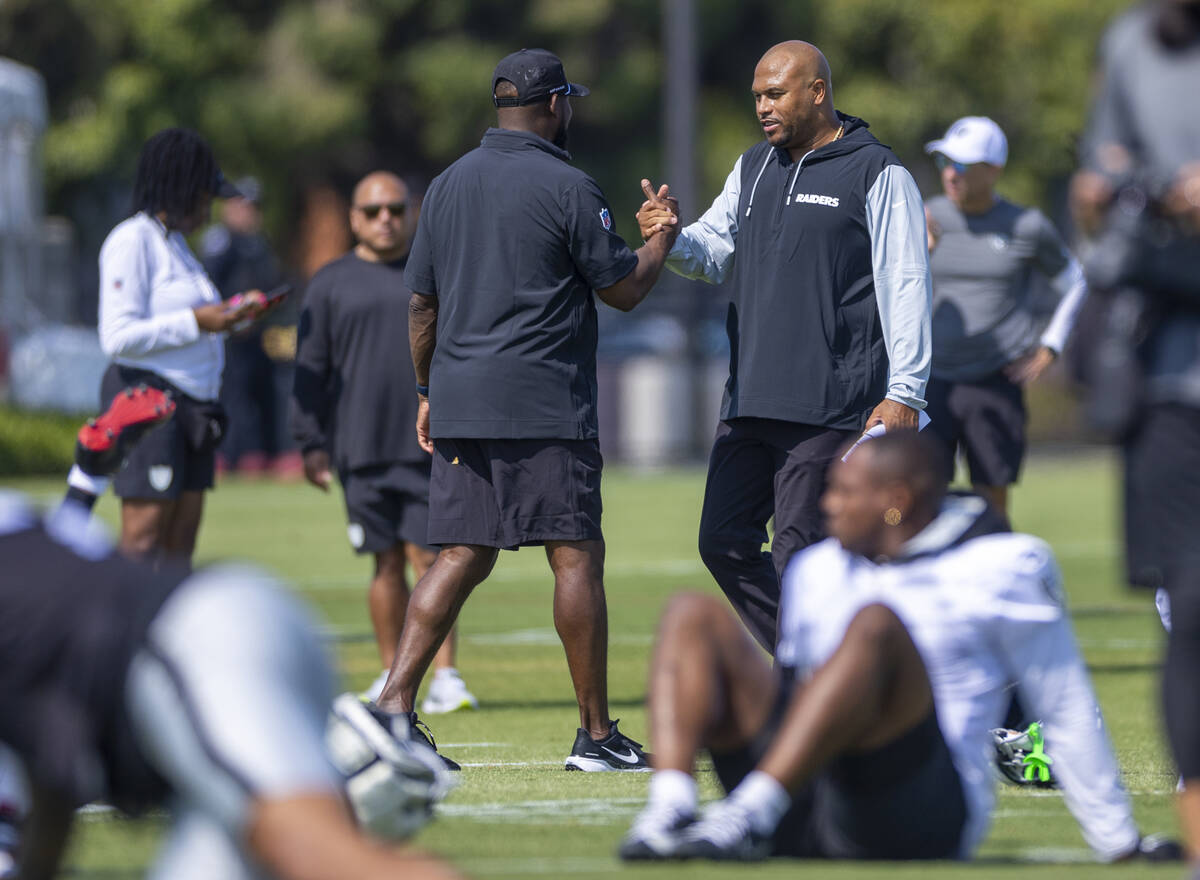 Raiders head coach Antonio Pierce greets running backs coach Carnell Williams during the first ...