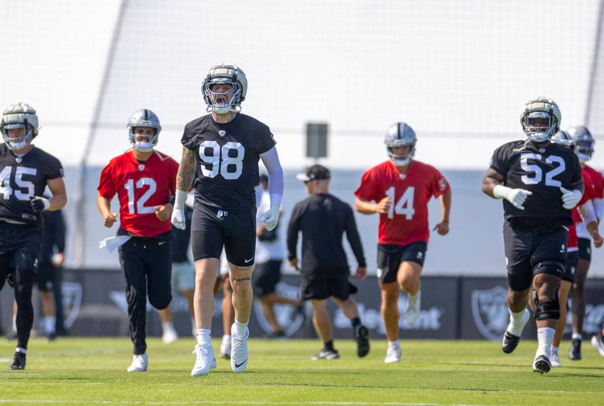 Raiders defensive end Maxx Crosby (98) yells out while warming up during the first day of train ...