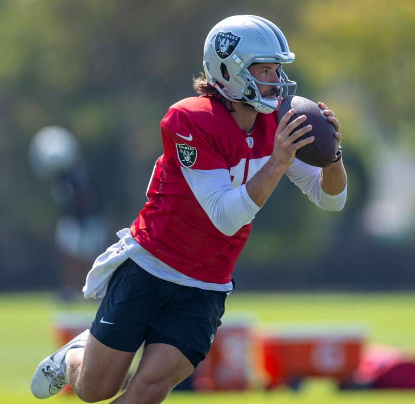 Raiders quarterback Gardner Minshew (15) grabs a ball and looks to pass during the first day of ...