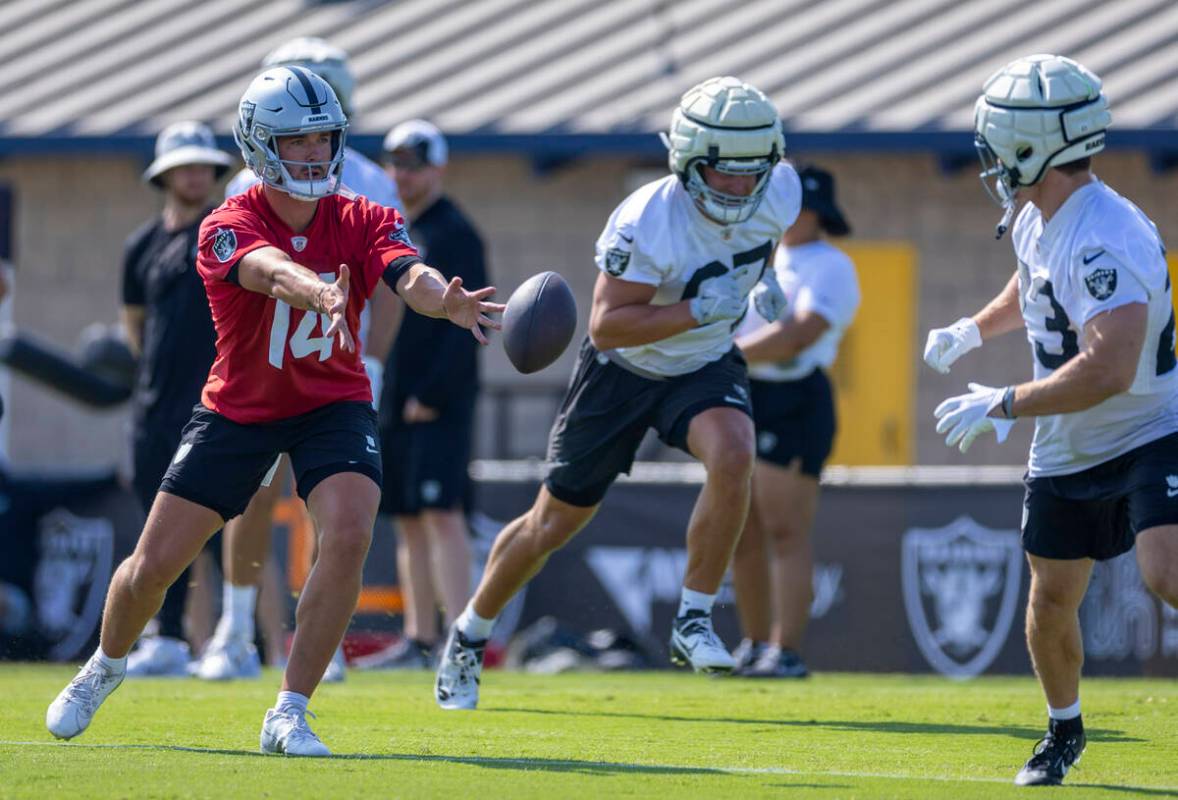 Raiders quarterback Carter Bradley (14) tosses the ball to running back Dylan Laube (23) during ...