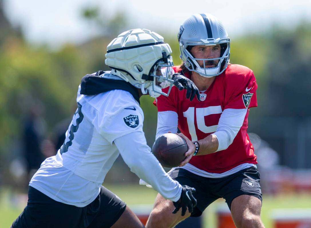 Raiders quarterback Gardner Minshew (15) hands the ball to running back Samir White (3) during ...