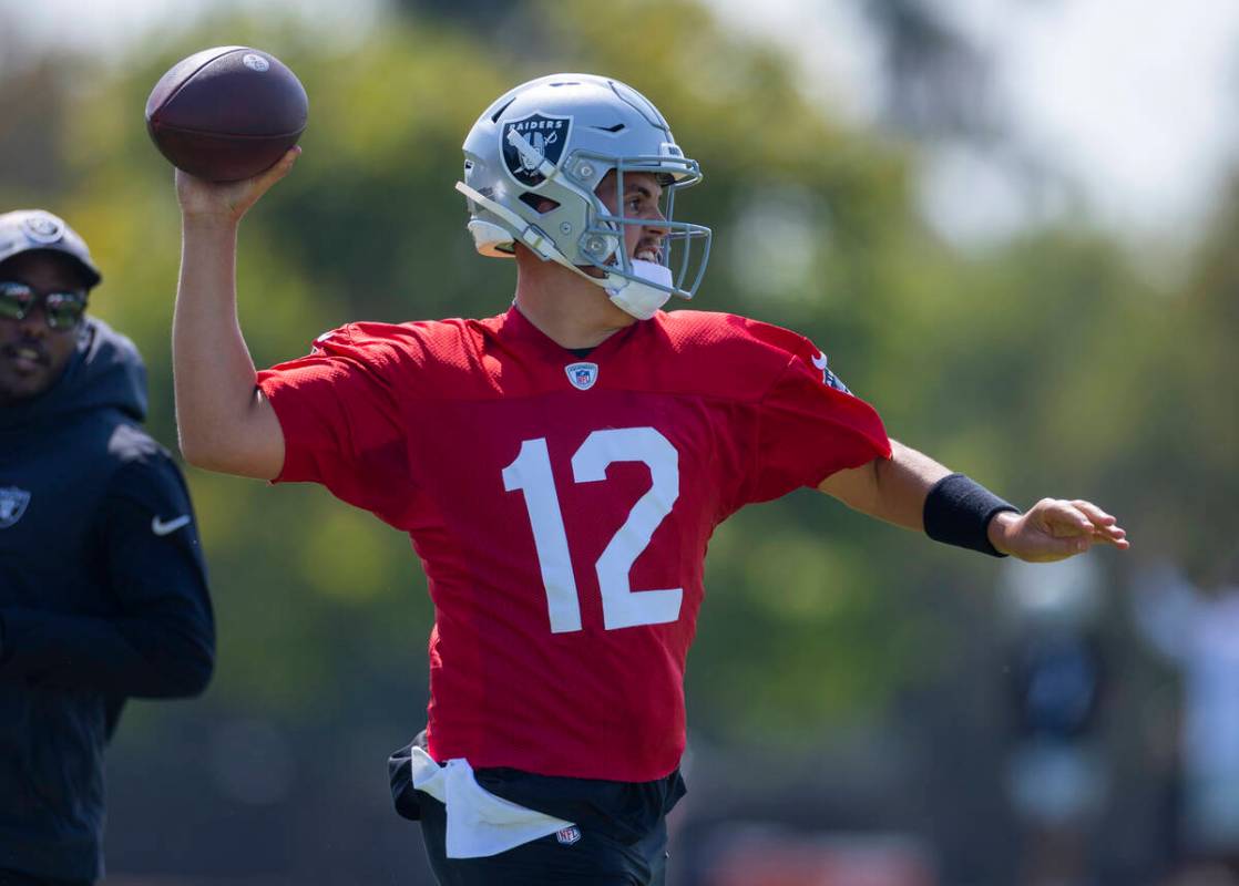 Raiders quarterback Aidan O'Connell (12) eyes a receiver during the first day of training camp ...