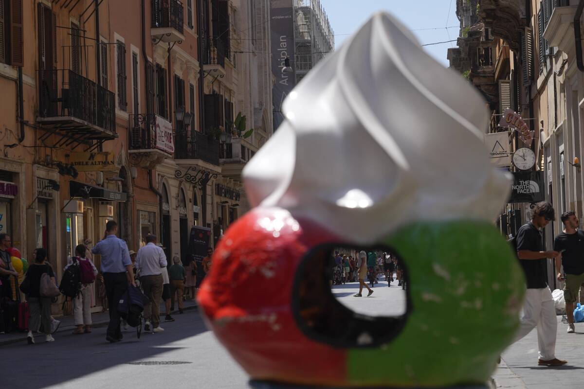 People stroll along Via del Corso shopping street as temperatures are reaching up to 37 Celsius ...
