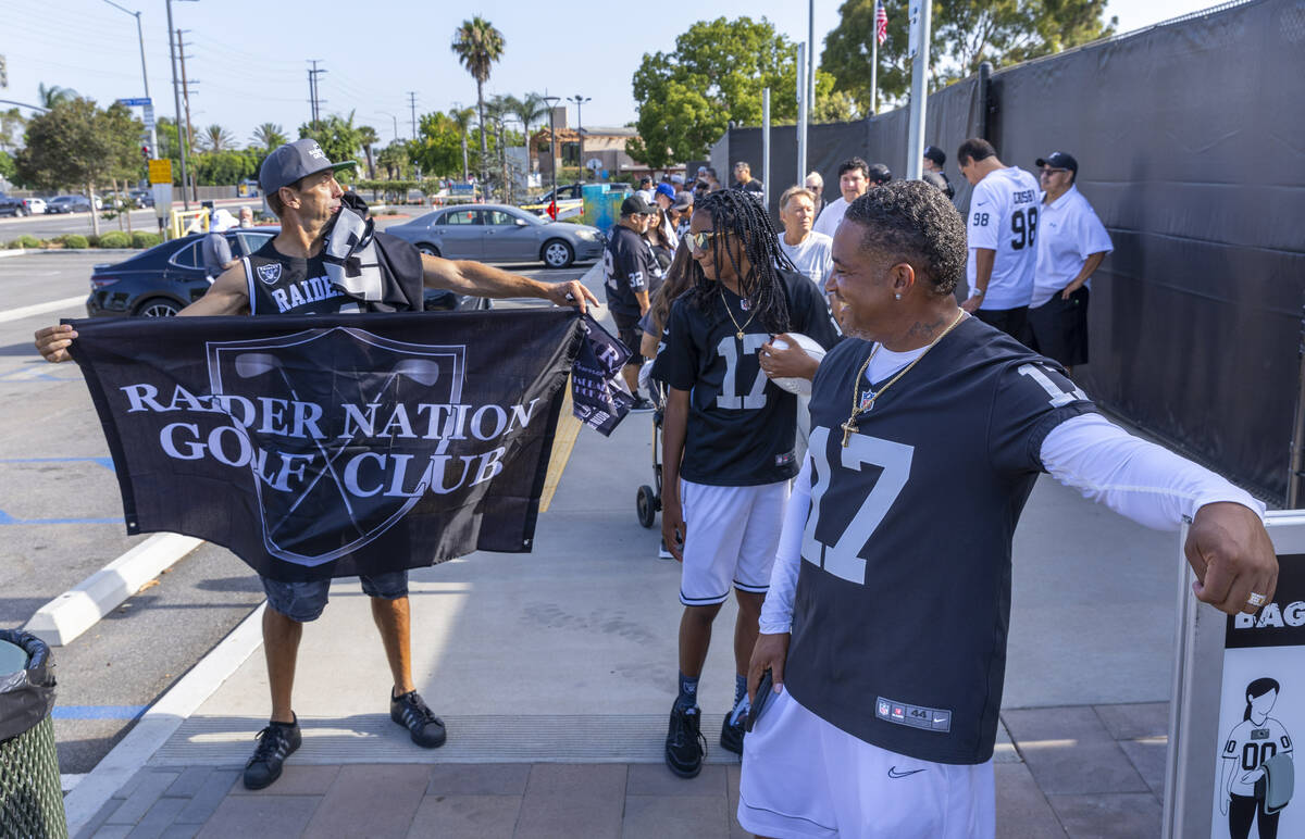 Raiders fans Tony Garcia waits in line to enter with Laron Evans, 12, and his father Ronald for ...