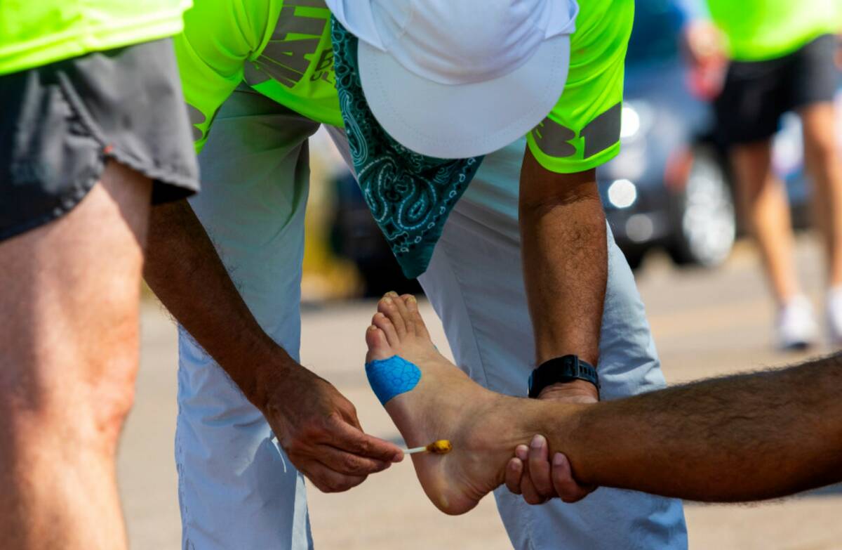 A crew member looks after a runners feet in alongside California Route 190 during the Badwater ...