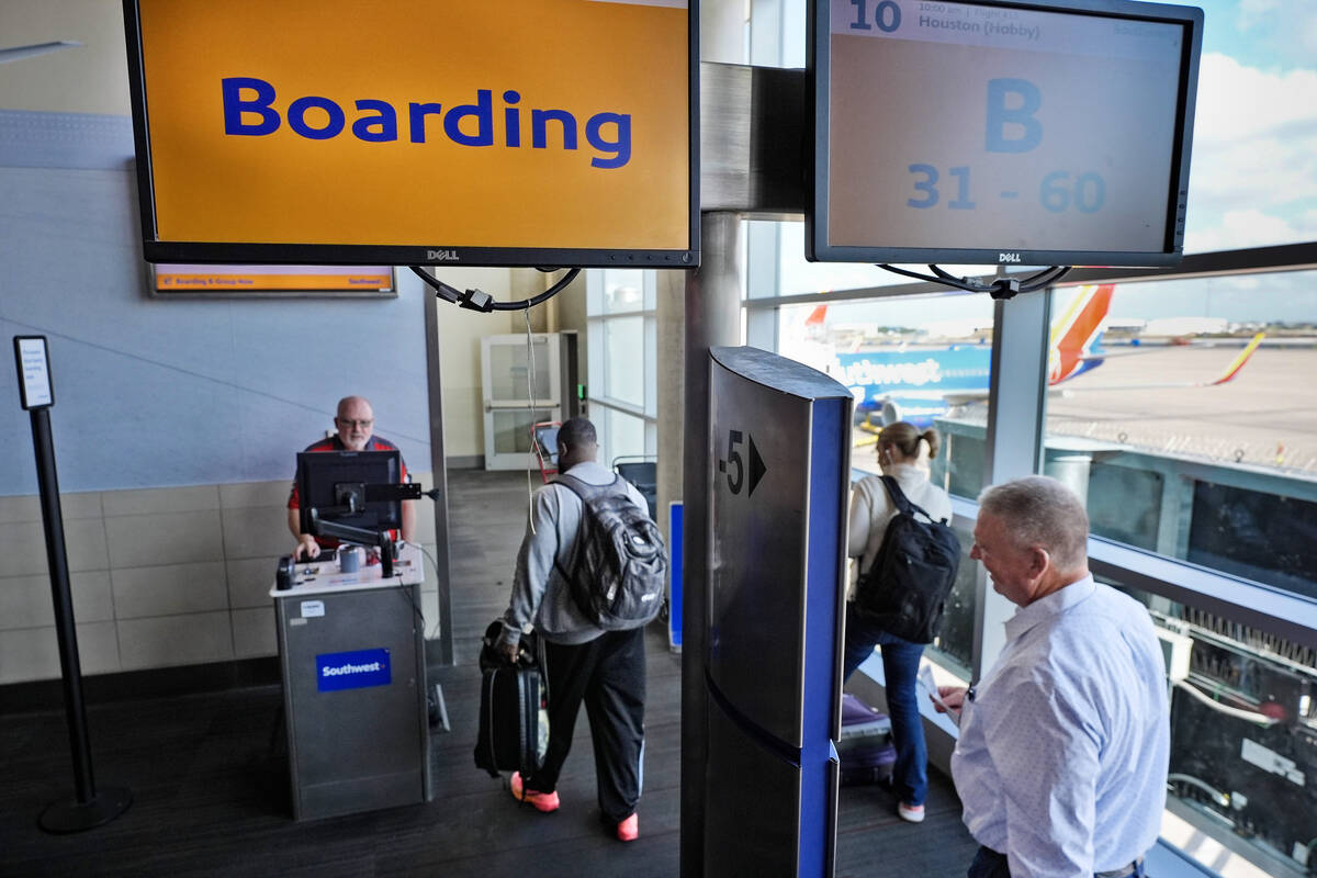 Travelers board a Southwest Airlines plane to depart from Love Field in Dallas, Thursday, July ...