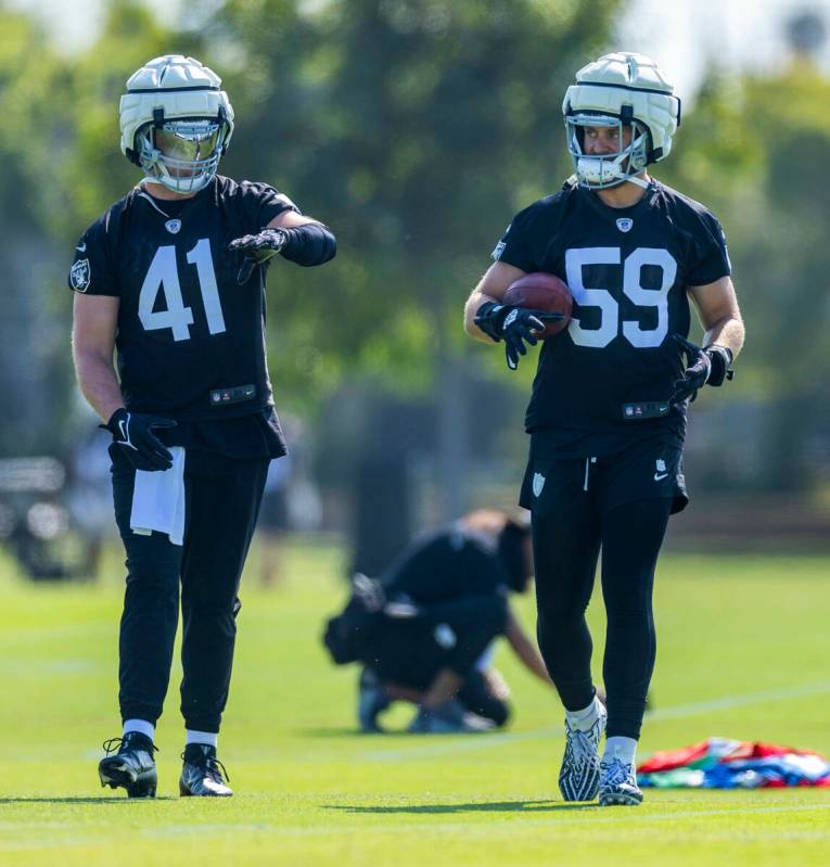 Raiders linebacker Robert Spillane (41) and linebacker Luke Masterson (59) talk while warming u ...