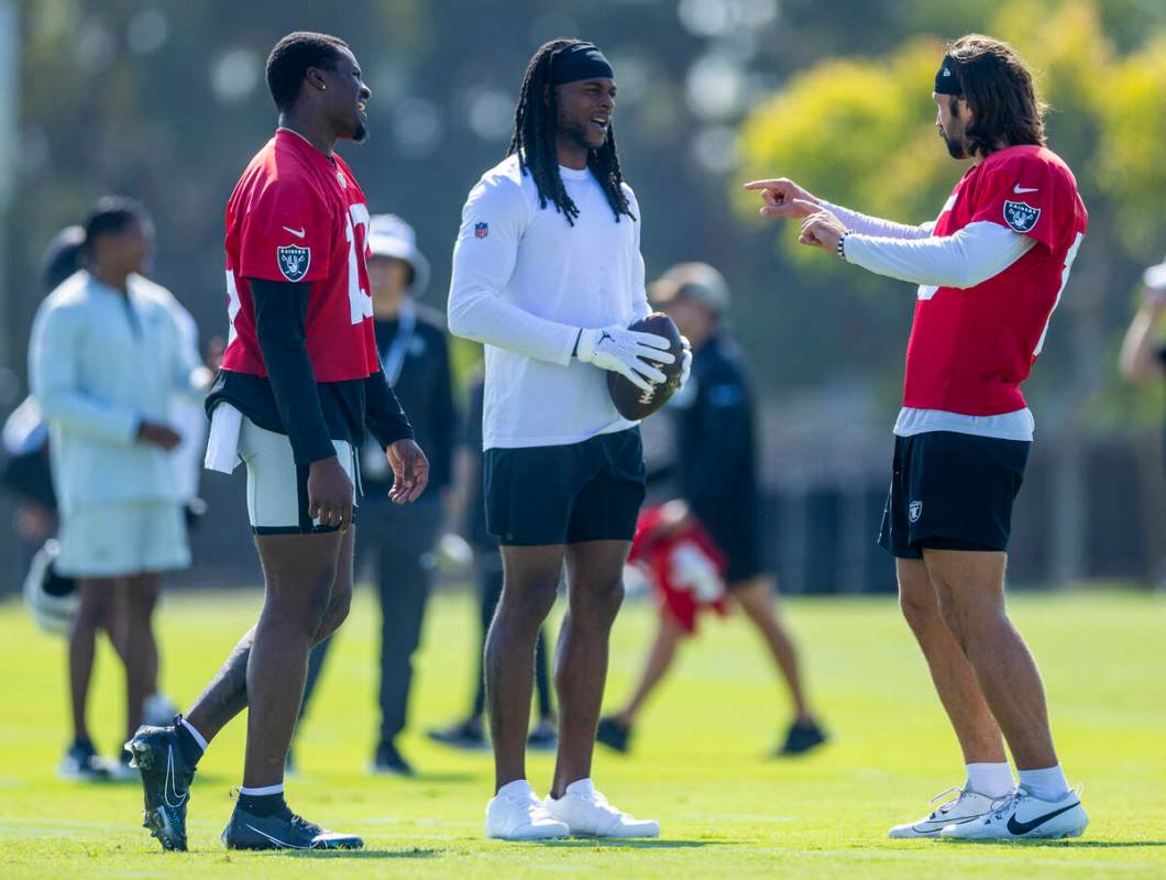 Raiders quarterback Anthony Brown Jr. (13) and wide receiver Davante Adams (17) listen to quart ...