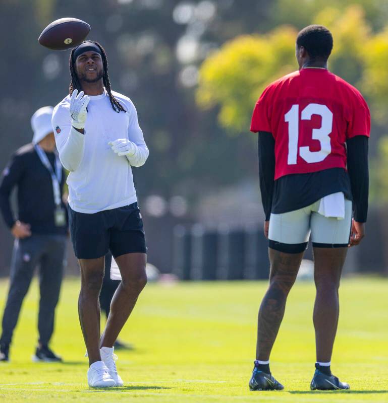 Raiders wide receiver Davante Adams (17) toss up a ball as quarterback Anthony Brown Jr. (13) l ...