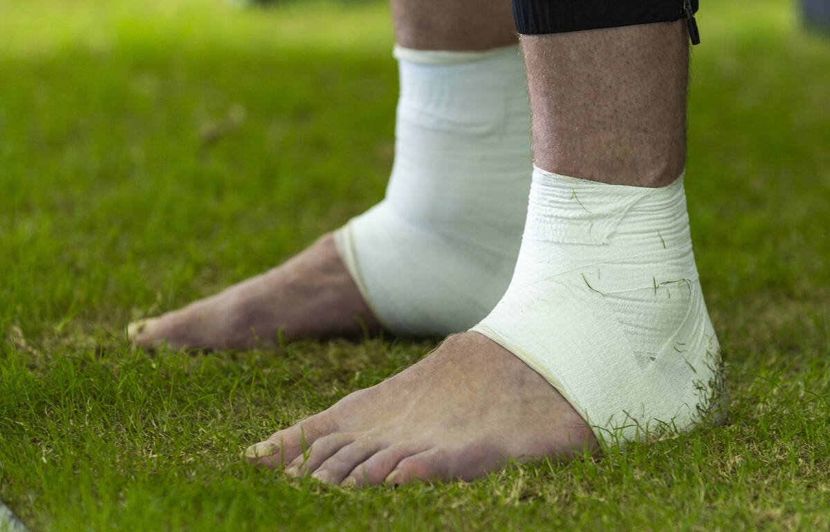 Raiders linebacker Robert Spillane (41) answers questions in bare feet during a media interview ...