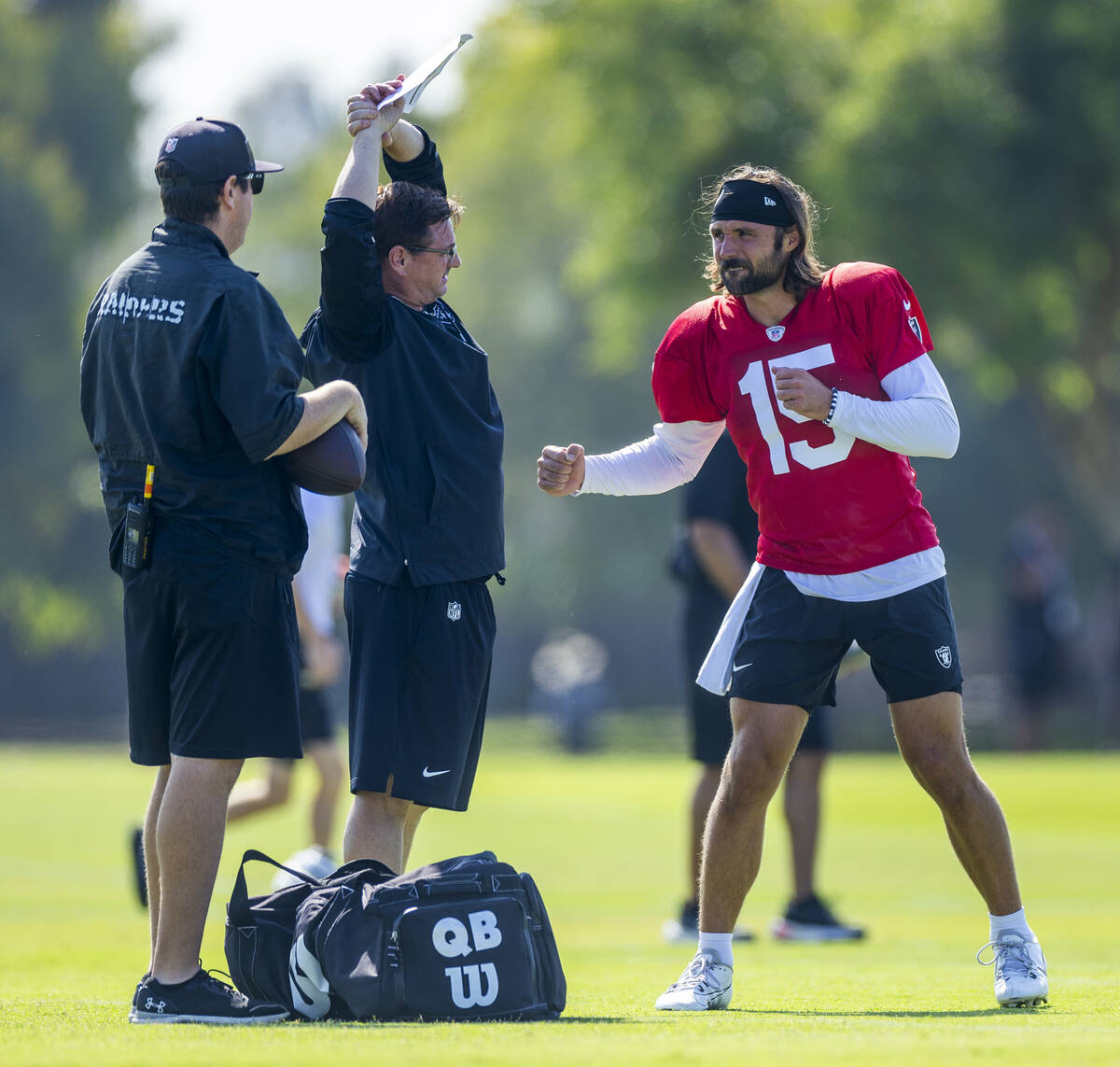 Raiders quarterback Gardner Minshew (15) throws a fake punch while talking with staff during th ...