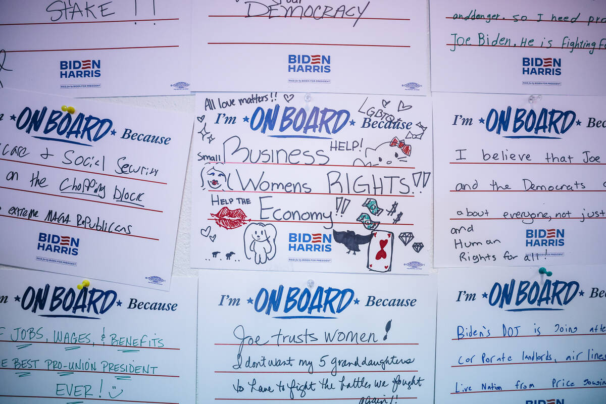 Notes from supporters who backed the Biden Harris campaign line the wall during an event to off ...