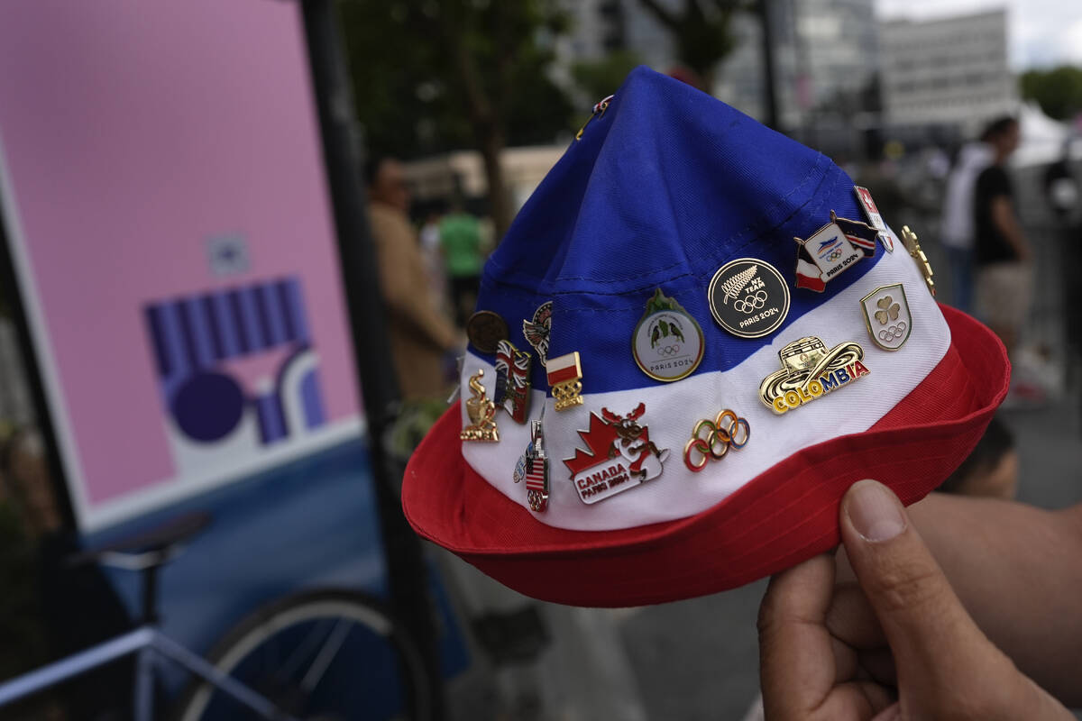 Neighborhood resident Lahlouh Wahab shows off all the 2024 Olympic pins he has been able to col ...