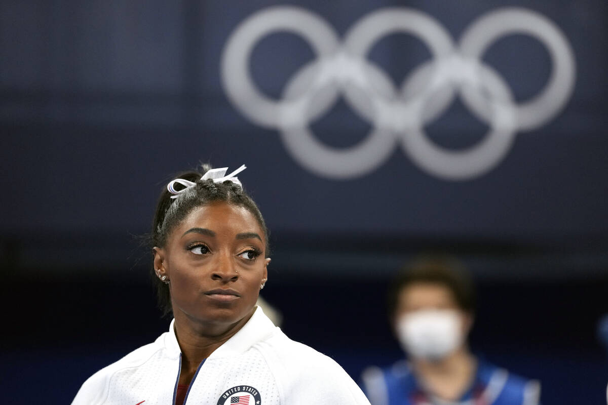 FILE - In this July 27, 2021 file photo, Simone Biles, of the United States, watches gymnasts p ...