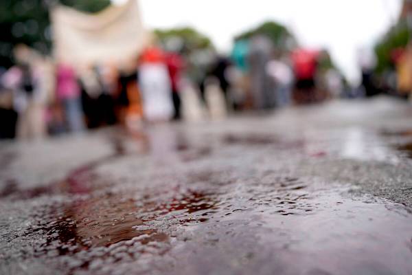 A red liquid poured by Hasidic Jews and others covers the street as they protest Israeli Prime ...