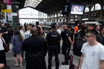 Travelers wait as police officers patrol inside the Gare du Nord train station at the 2024 Summ ...
