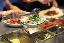 Chipotle restaurant workers fill orders for customers on April 27, 2015 in Miami, Florida. (Joe ...
