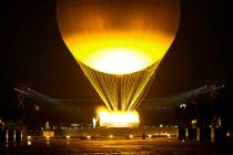 Teddy Riner and Marie-Jose Perec watch as the cauldron rises in a balloon in Paris, France, dur ...