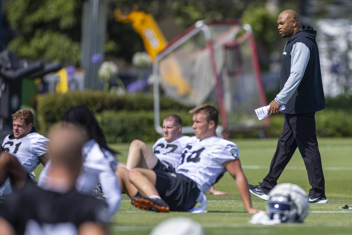 Raiders head coach Antonio Pierce walks about his players during the first day of training camp ...